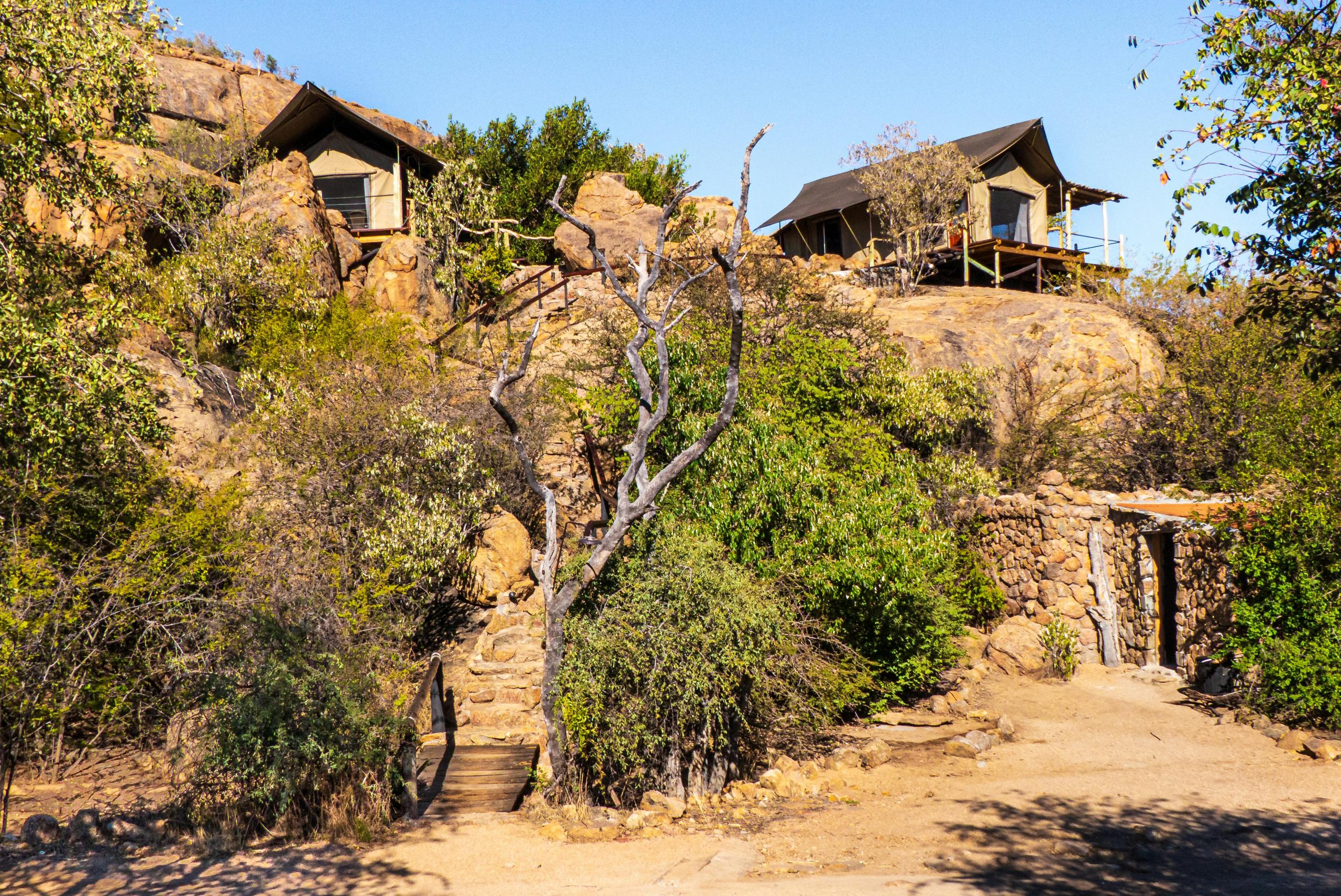 Best Safari Lodges in Serengeti: Where to Stay, Rustic safari lodges surrounded by rocky landscape and desert vegetation, perfect for an adventurous retreat.